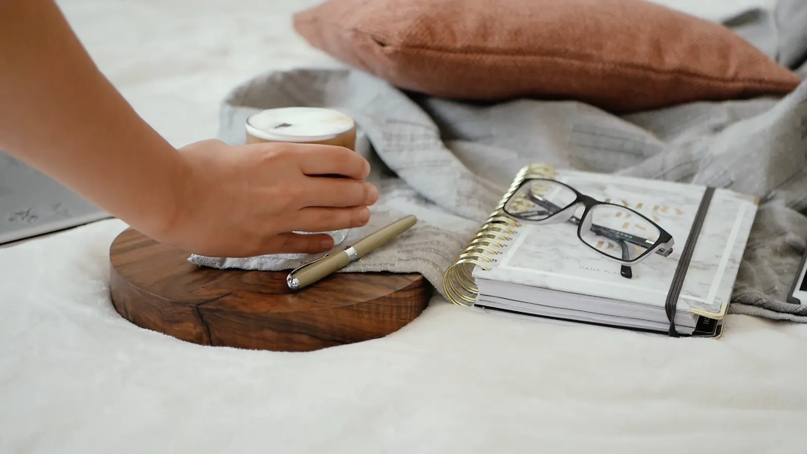 A planner, pen and coffee on a bright desk
